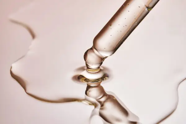 Detail of a white toothbrush with blue, white and pink bristles on a pink background. Concept of oral hygiene, teeth, dentist and caries.