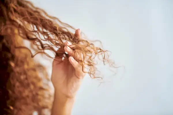 woman running fingers through curly hair