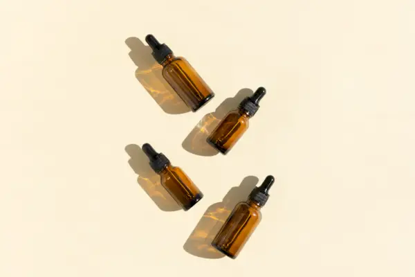 Bottles of dark amber glass with essential, lotion, serum on a beige background. Natural SPA organic cosmetic