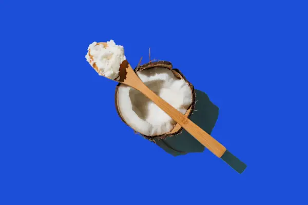Ripe coconuts, coconut oil on blue background. Health and wellness concept. Minimal flat lay style. Top view.