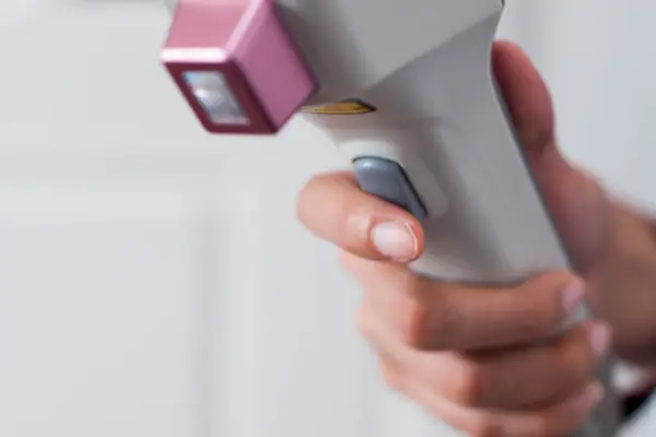 A young Southeast Asian female doctor is using a laser for a medical procedure