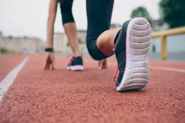 Woman on tartan track in starting position