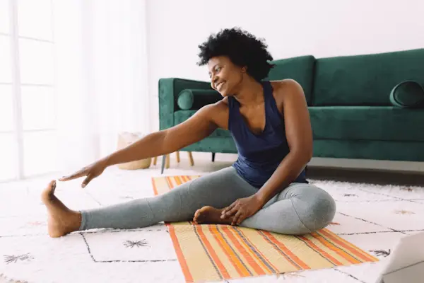 African woman doing stretching at home
