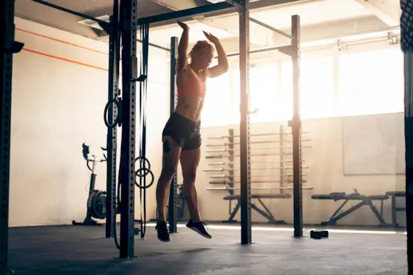 Young woman, doing burpees at the modern gym