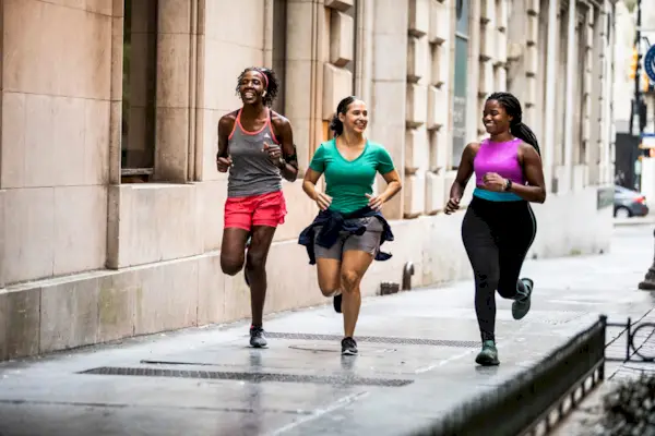 Group of women running through urban area