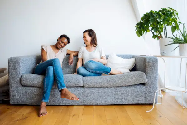 couple at home snuggling under blanket