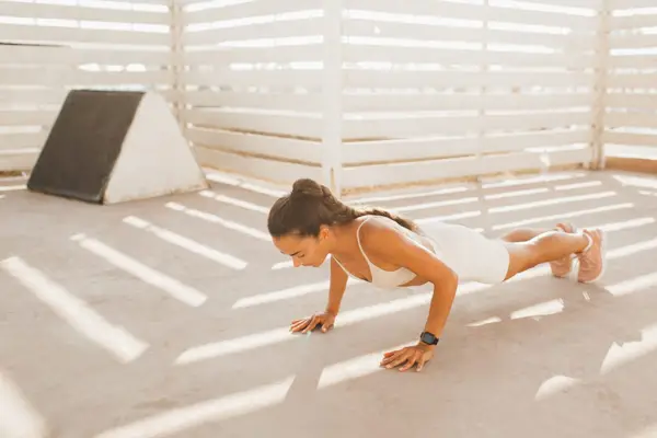 Strength woman doing push-ups. Effort and endurance on interval tabata fitness training