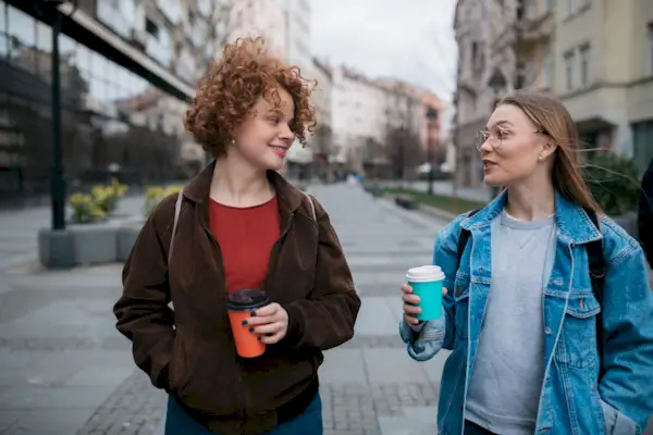Two female friends walking through the city