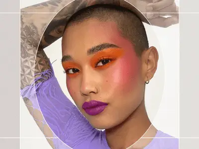 Portrait of AAPI Subject with Buzzcut Wearing Bold Orange Eyeshadow that Blends into Pink Blush Draping and Purple Lipstick