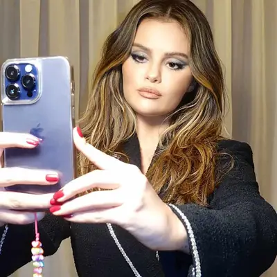 Selena Gomez taking mirror selfie showing off red cranberry nails
