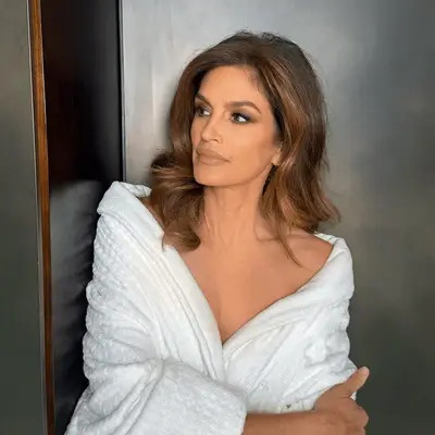 Cindy Crawford in a white robe looking to the side