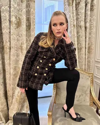 Camille Razat standing with her leg on a chair, a hand on her face