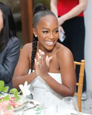 Actor Aja Naomi King, hands clasped and smiling