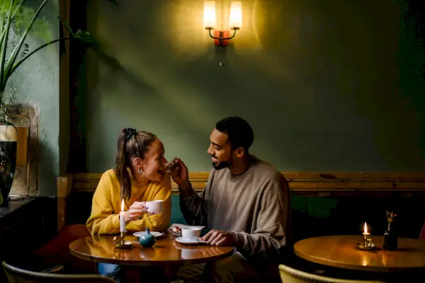 Smiling Lesbians Enjoying Coffee On Table