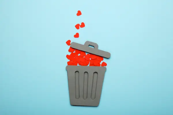 End of love and couple relationship. Discarded red hearts in trash