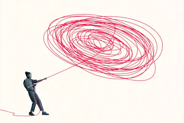 Woman pulling vibrant red rope from tangle