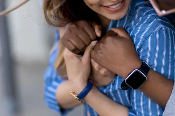 Closeup of an interracial lesbian couple holding hands and hugging