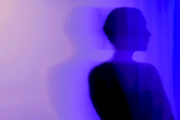 Silhouette of a woman on a purple background with copy space.