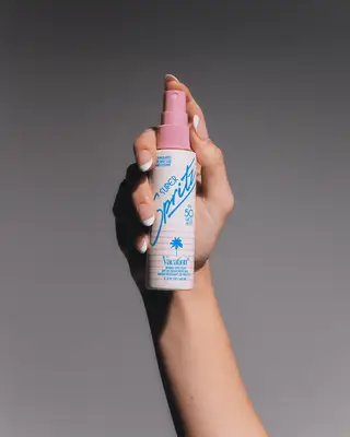 Manicured hand holding Vacation Super Spritz SPF Face Mist