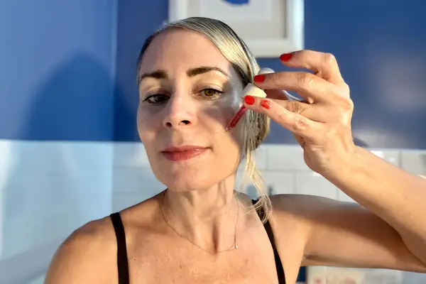 Jill applying product to her face