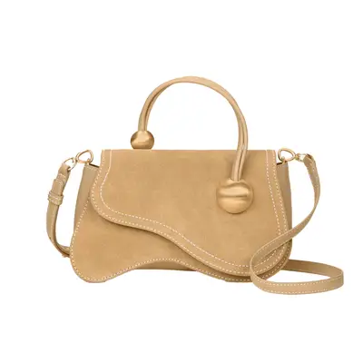 Jordan Daniels wearing dress and holding brown suede handbag