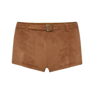 A woman wearing a raffia hat looks up with a serene expression, the sky in the background