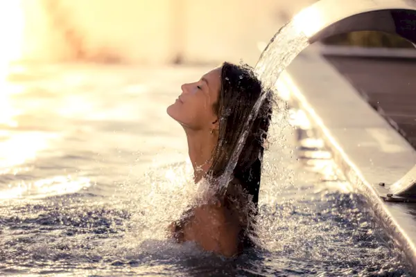 Smiling woman having hydrotherapy in the pool.