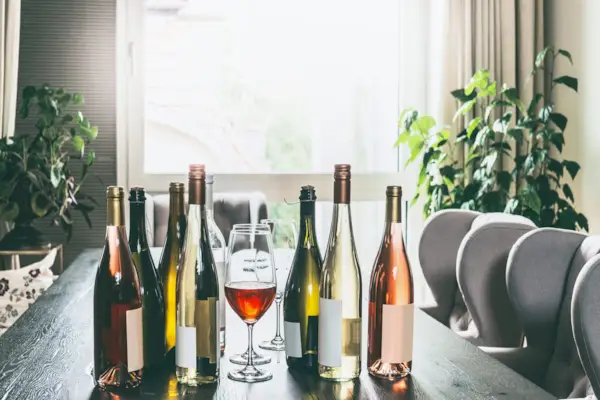 Variety of wine bottles and glasses on table in modern living room