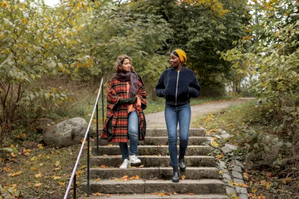 Two young women walking in park