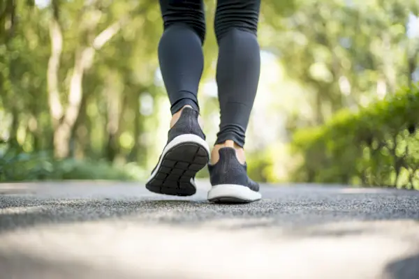 view of white shoes of a woman in close-up walking up stairs outdoors