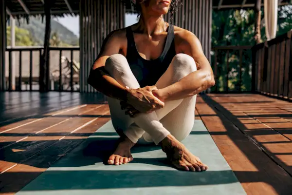 Relaxed woman with dog practicing Yoga in cobra pose at home.