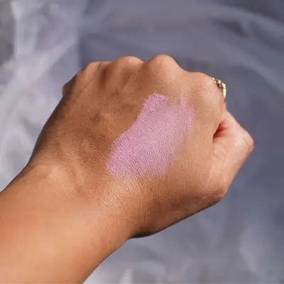 Close-up of hand with baby pink Tower 28 blush swatch