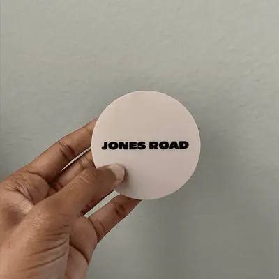 Hand holding Jones Road Bronzer closed compact