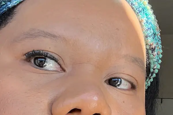 mascara cils princesse appliqué sur l'un des yeux de Nicole tandis que l'autre reste sans mascara