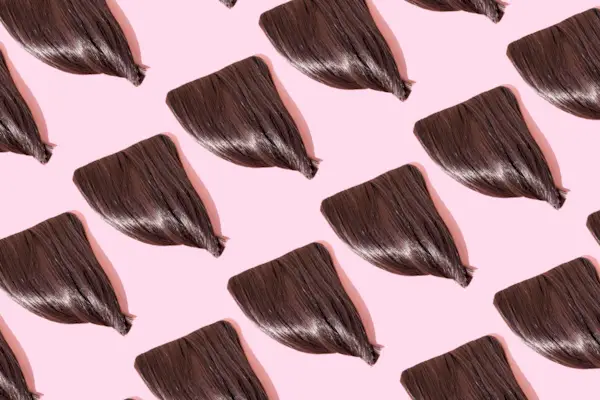 Close-up of repeated fringes on pink background