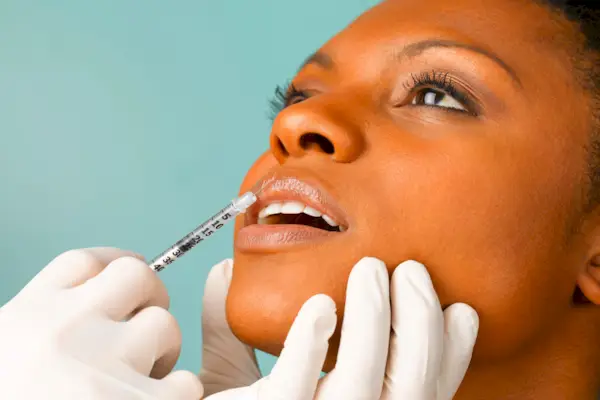 Person injecting botox into woman