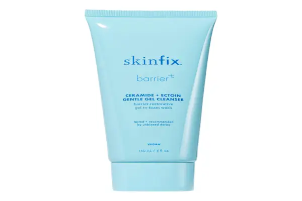 An unrecognizable person doing full body red light therapy in a dark room