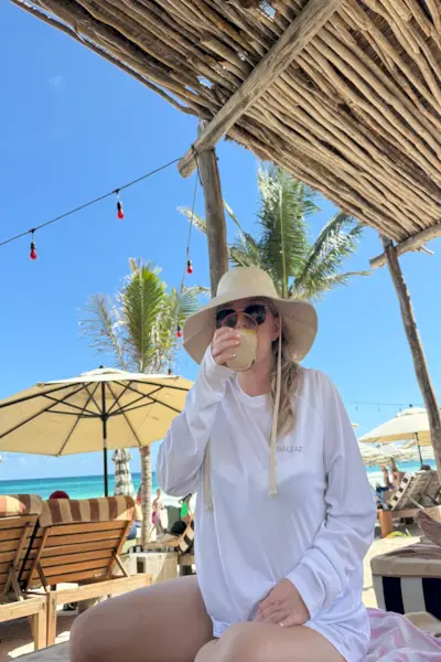 La scrittrice Emily Haley si gode la vacanza rilassandosi sotto una capanna e indossando una tutina per proteggersi dal cancro alla pelle.