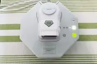 Iluminage Touch 4ever Home Permanent Hair Removal IPL & Radio Frequency System displayed on green striped cloth