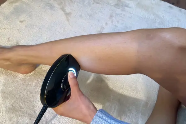 Hand using SmoothSkin Pure Mini Intelligent Ultrafast IPL Permanent Hair Reduction on leg