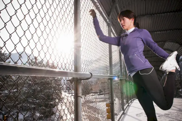 Runner stretching on urban walkway