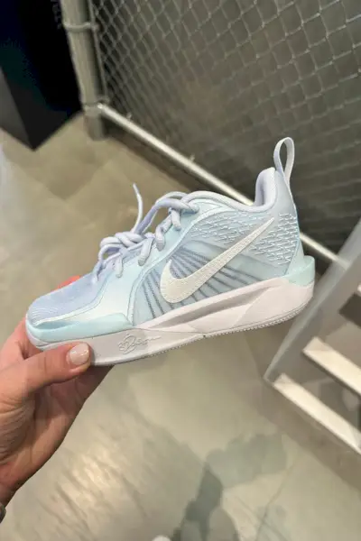 ruka držící pár bot