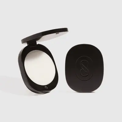 Black compact open with white solid fragrance inside