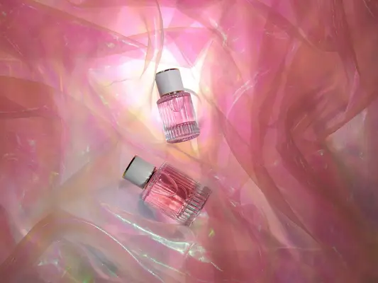 Transparent glass perfume bottles in folds of chiffon fabric