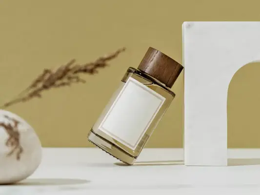 A bottle of perfume leaning over onto a decorative piece of marble