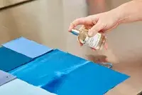 A person sprays Le Labo Santal 33 Eau de Parfum onto fabric