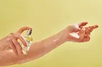 A person sprays Le Labo Santal 33 Eau de Parfum onto their wrist