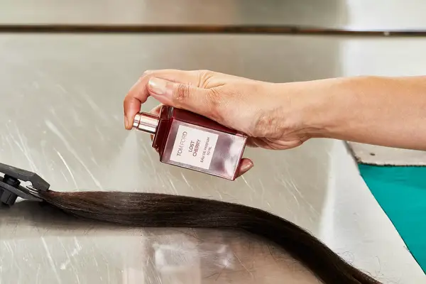 A person sprays Tom Ford Lost Cherry Eau de Parfum onto hair