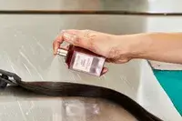 A person sprays Tom Ford Lost Cherry Eau de Parfum onto hair