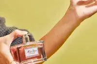 A person sprays DIOR Miss Dior Eau de Parfum onto their wrist